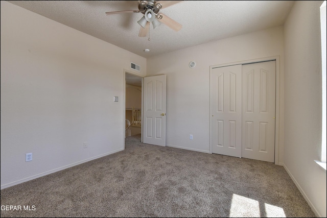 unfurnished bedroom featuring a closet, a textured ceiling, baseboards, carpet flooring, and visible vents