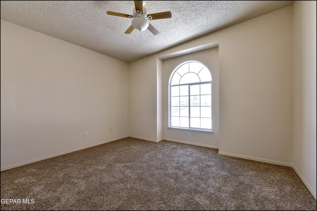 carpeted empty room featuring ceiling fan, a textured ceiling, and baseboards