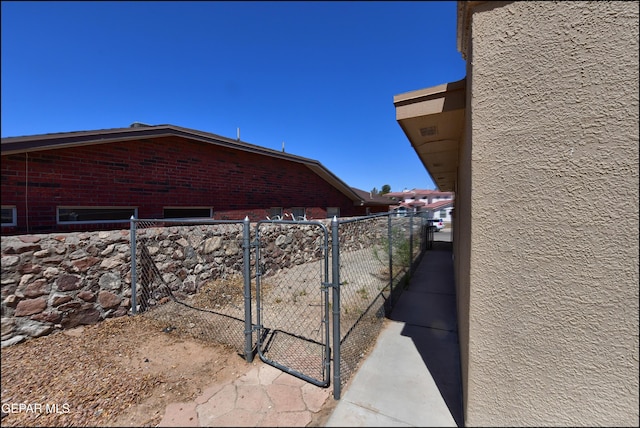 view of side of home featuring a gate and fence