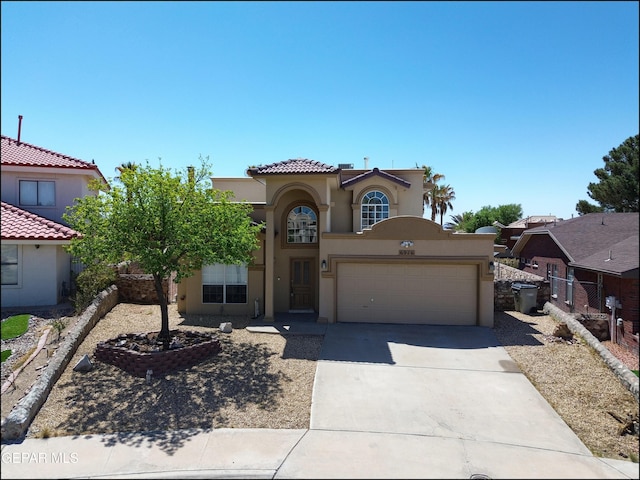 mediterranean / spanish-style home featuring concrete driveway, stucco siding, a garage, and a tile roof