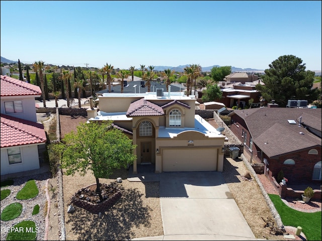 view of front facade with a tiled roof, stucco siding, driveway, and a residential view