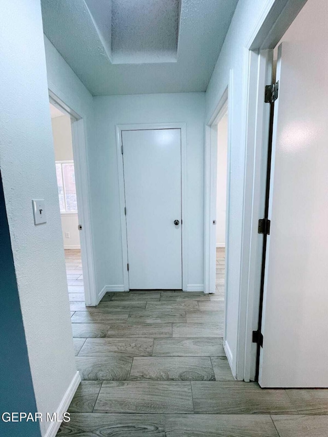 hall with baseboards and wood finished floors