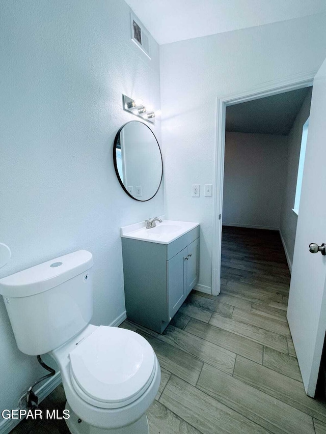bathroom with visible vents, baseboards, toilet, and vanity