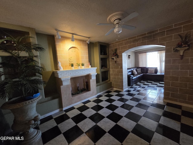 306 SW A St SW, Fabens, TX 79838 - interior space with track lighting, a ceiling fan, a textured ceiling, and arched walkways