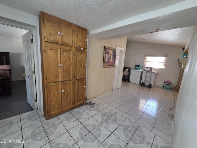 306 SW A St SW, Fabens, TX 79838 - corridor with washer / dryer, a textured ceiling, and light tile patterned flooring