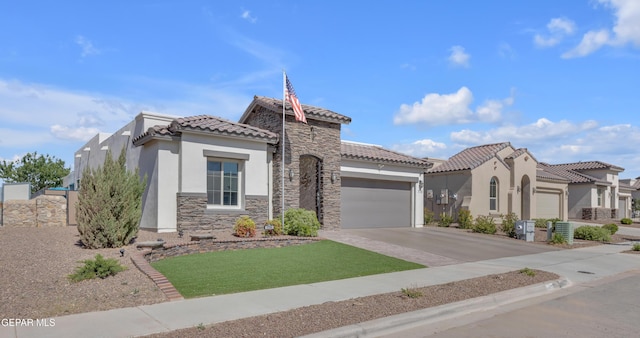 mediterranean / spanish-style home with driveway, a tile roof, an attached garage, stone siding, and stucco siding