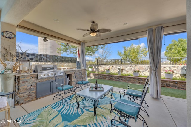 view of patio / terrace with area for grilling, an outdoor kitchen, fence, and a ceiling fan