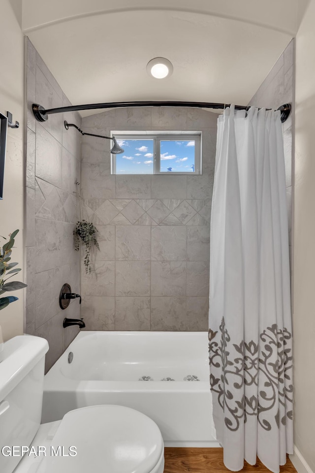 bathroom with shower / tub combo, wood finished floors, and toilet