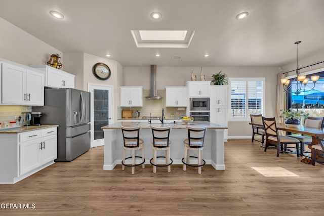 kitchen with recessed lighting, appliances with stainless steel finishes, backsplash, and wall chimney range hood