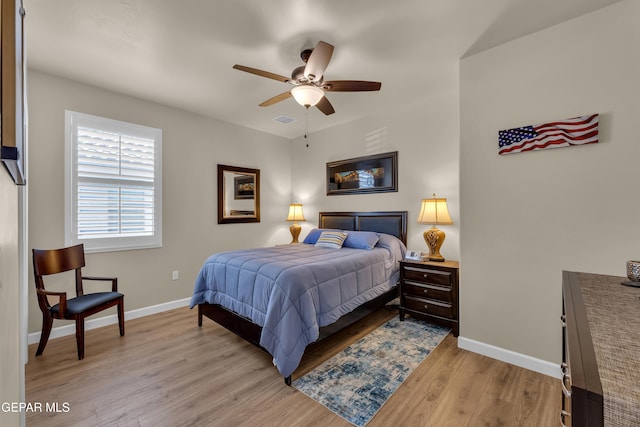 bedroom featuring light wood-style floors, baseboards, ceiling fan, and visible vents