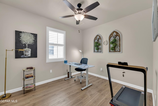 home office with a ceiling fan, baseboards, and light wood-style floors
