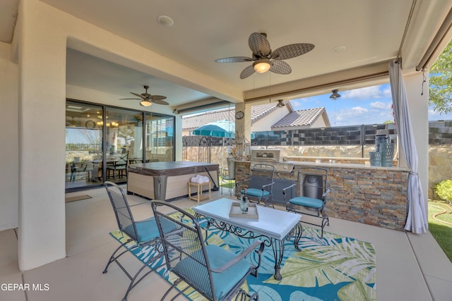 view of patio / terrace with a ceiling fan, a hot tub, and fence