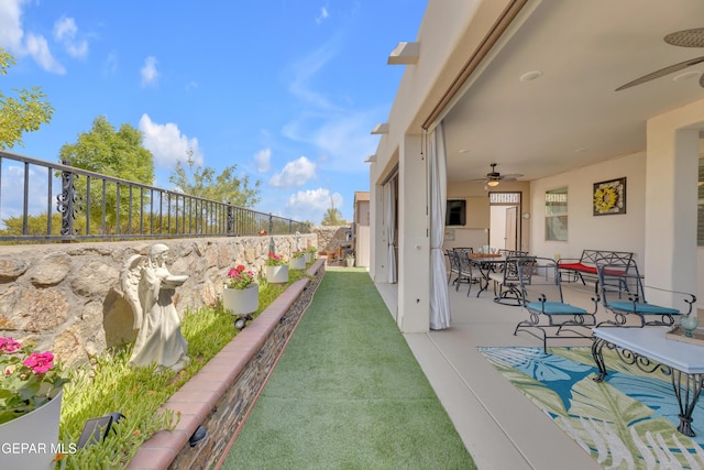 view of yard featuring outdoor dining area, a fenced backyard, ceiling fan, and a patio area