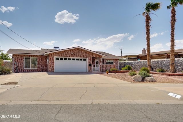98 Northwind Dr, El Paso, TX 79912 - ranch-style house with a garage, concrete driveway, brick siding, and fence