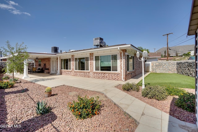 98 Northwind Dr, El Paso, TX 79912 - rear view of house featuring brick siding, fence, a patio, and central AC unit
