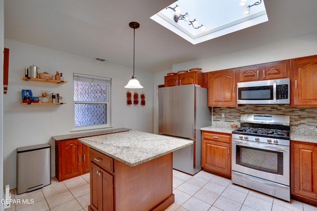 98 Northwind Dr, El Paso, TX 79912 - kitchen with stainless steel appliances, a skylight, light tile patterned floors, and tasteful backsplash