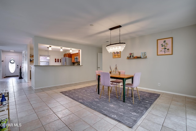 98 Northwind Dr, El Paso, TX 79912 - dining space featuring light tile patterned flooring, a chandelier, and baseboards