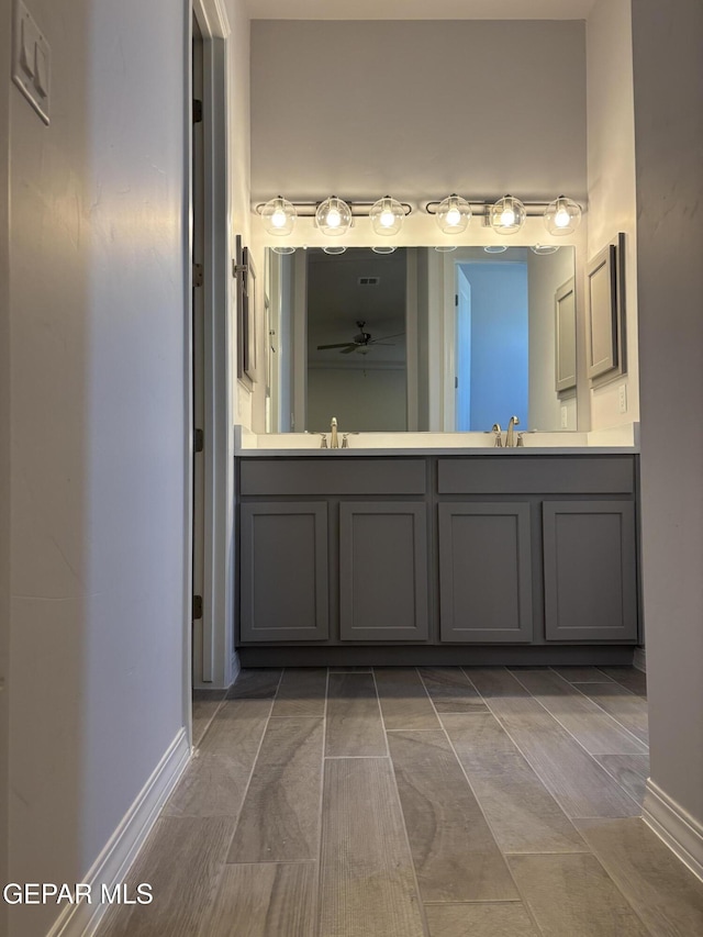 full bath featuring a ceiling fan, double vanity, and baseboards