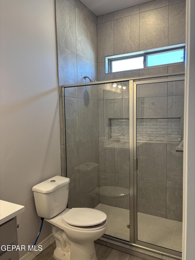 full bath with a shower stall, toilet, and vanity