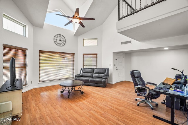 office featuring ceiling fan, high vaulted ceiling, visible vents, and wood finished floors