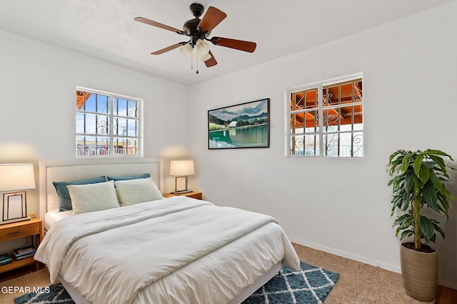 carpeted bedroom featuring baseboards and ceiling fan
