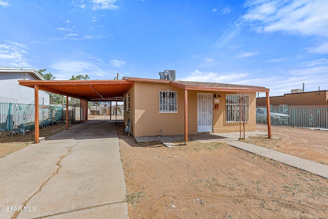 manufactured / mobile home with stucco siding, fence, driveway, and an attached carport