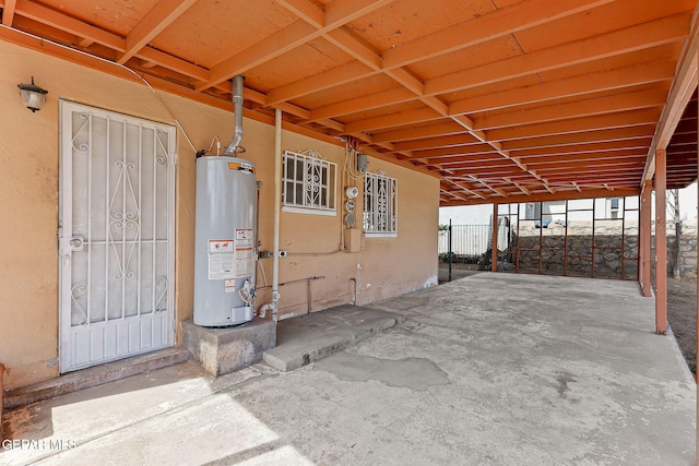 view of patio with water heater and fence