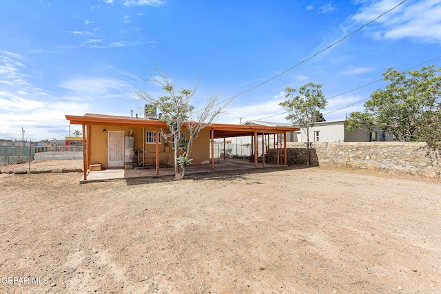 back of property with fence and a patio