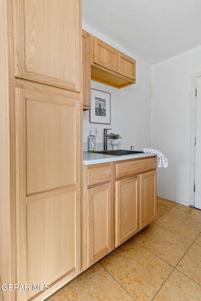 kitchen featuring light brown cabinets, light tile patterned flooring, and light countertops