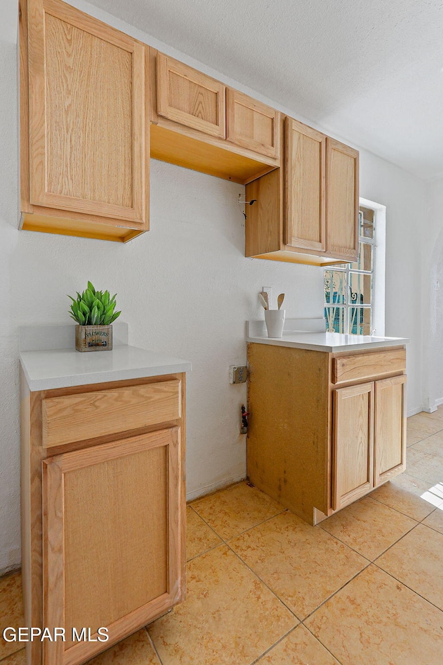 kitchen featuring light tile patterned floors, light countertops, and light brown cabinets