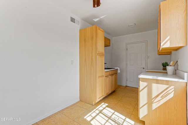 kitchen featuring light countertops, light tile patterned floors, and baseboards