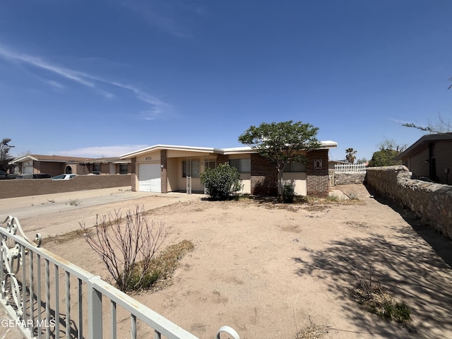 8725 Plains Dr, El Paso, TX 79907 - view of front of home featuring brick siding, driveway, fence, and a garage