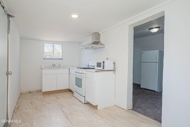 219 Dolan St, El Paso, TX 79905 - kitchen with light countertops, a sink, white cabinets, white appliances, and wall chimney range hood