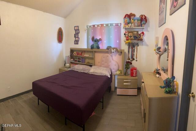 11772 Corona Crest Ave, El Paso, TX 79936 - bedroom with lofted ceiling and wood finished floors