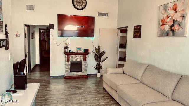 11772 Corona Crest Ave, El Paso, TX 79936 - living room with wood finished floors, a stone fireplace, baseboards, and a towering ceiling