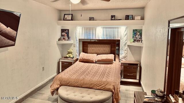 11772 Corona Crest Ave, El Paso, TX 79936 - bedroom with wood finished floors, a textured ceiling, baseboards, and a textured wall