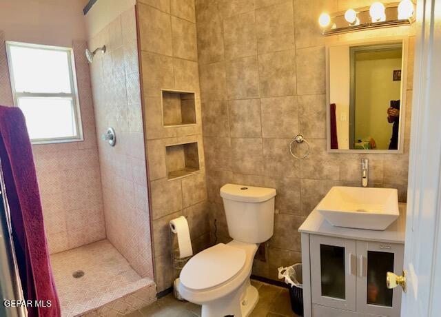 11772 Corona Crest Ave, El Paso, TX 79936 - full bath with tiled shower, toilet, vanity, and tile walls