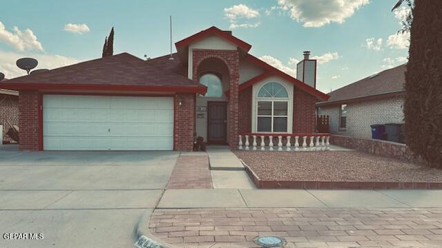 view of front facade with a garage, brick siding, and driveway