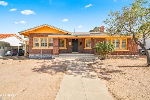 3020 Wheeling Ave, El Paso, TX 79930 - view of front facade featuring a carport, brick siding, covered porch, and a chimney