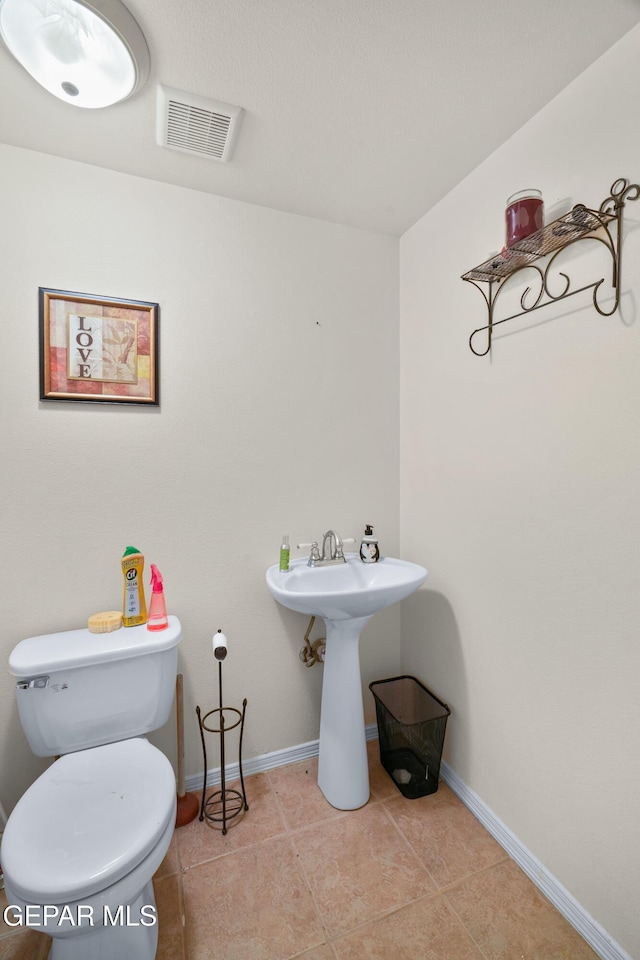 3020 Wheeling Ave, El Paso, TX 79930 - bathroom with toilet, tile patterned flooring, baseboards, and a sink