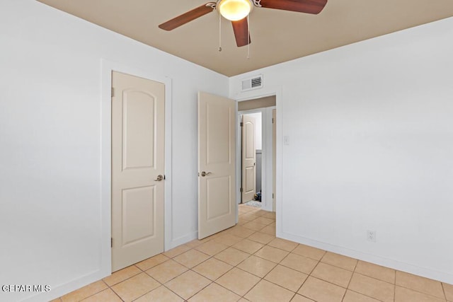spare room with ceiling fan, baseboards, and light tile patterned floors