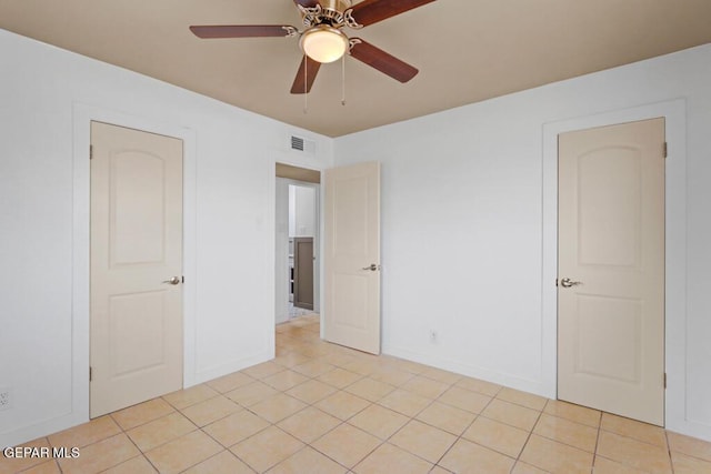 spare room featuring ceiling fan, baseboards, and light tile patterned flooring
