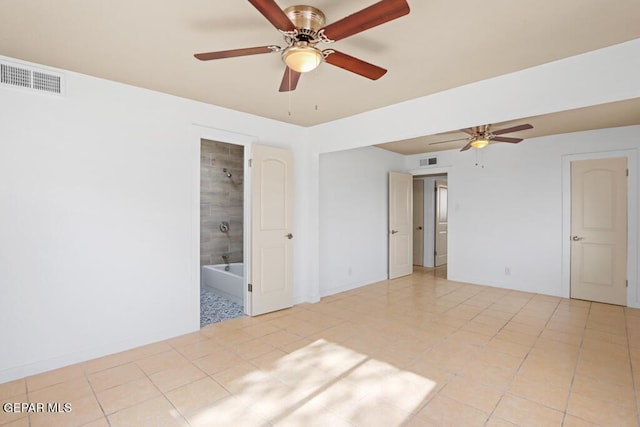 empty room with a ceiling fan, light tile patterned flooring, and baseboards