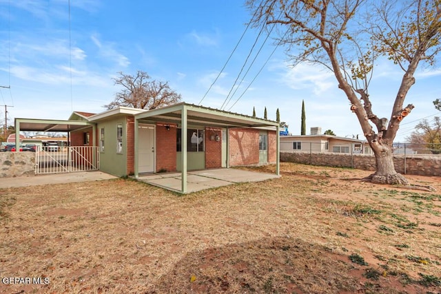 rear view of property featuring brick siding and a carport
