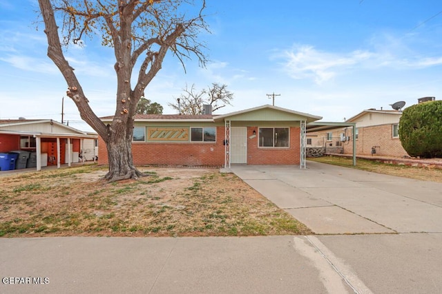 ranch-style house featuring brick siding and driveway