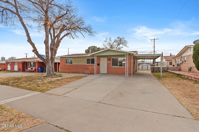 ranch-style home featuring a carport, brick siding, and driveway