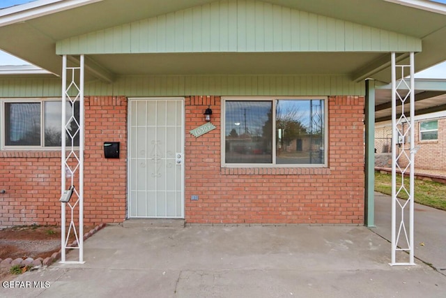 entrance to property featuring brick siding