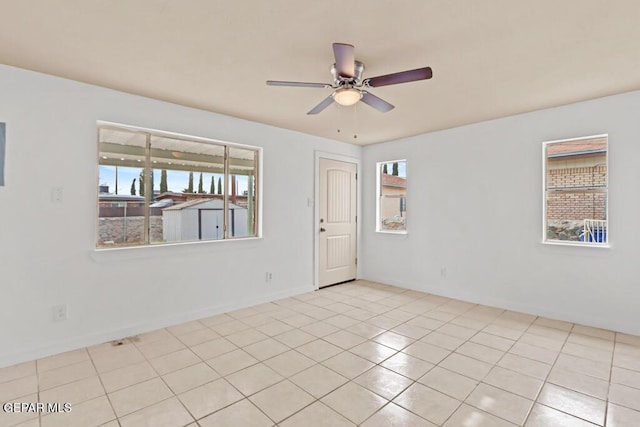 spare room with ceiling fan, baseboards, and tile patterned floors