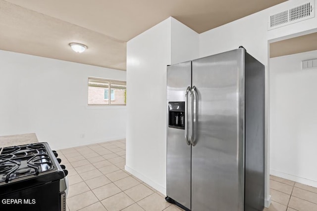 kitchen with stainless steel appliances, light tile patterned floors, baseboards, and light countertops