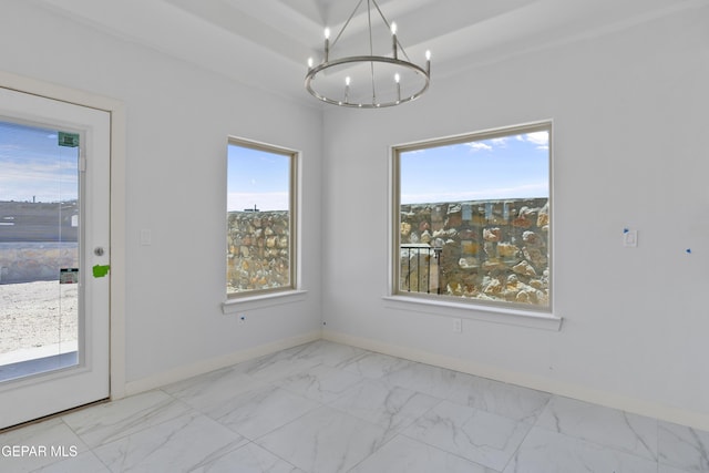 unfurnished dining area featuring an inviting chandelier, a wealth of natural light, baseboards, and marble finish floor